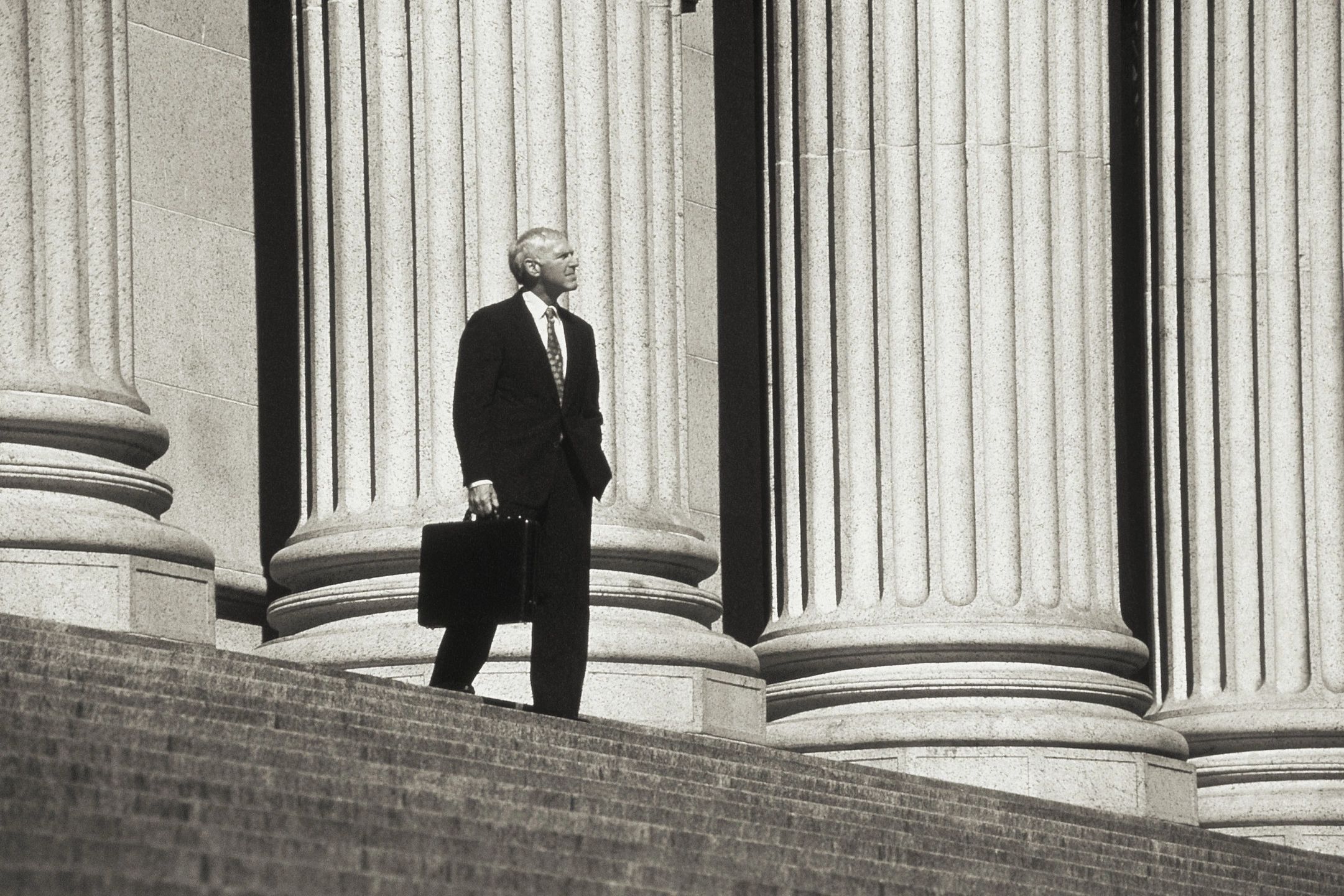 man walking out of court house with briefcase